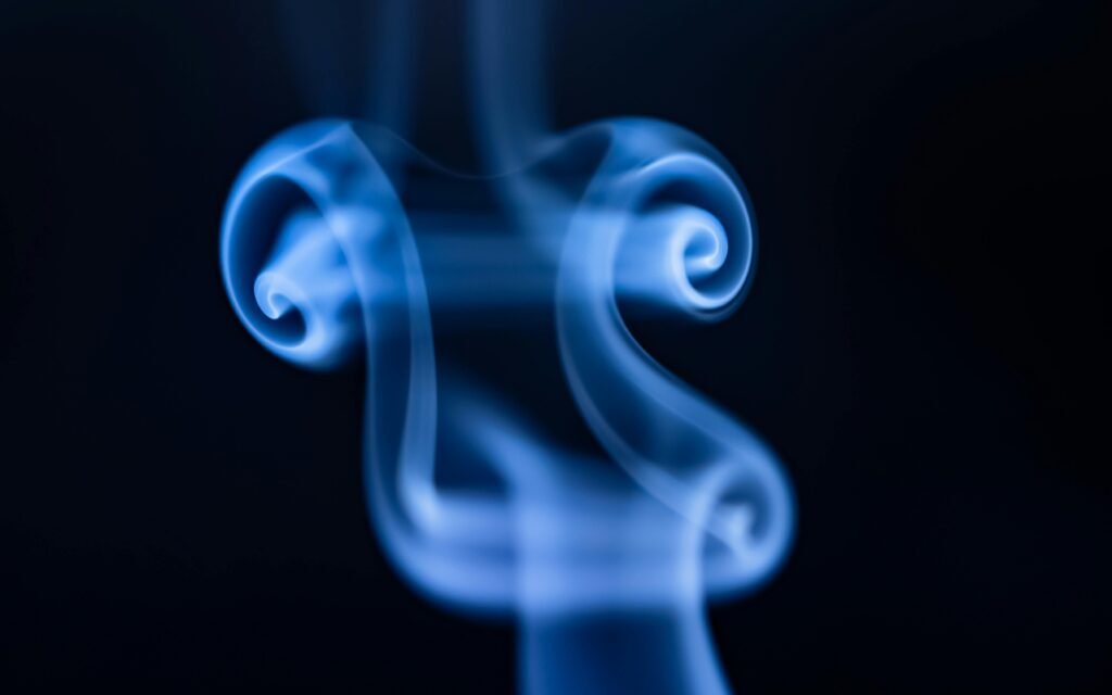Abstract close-up of ethereal blue smoke swirls on a dark backdrop.